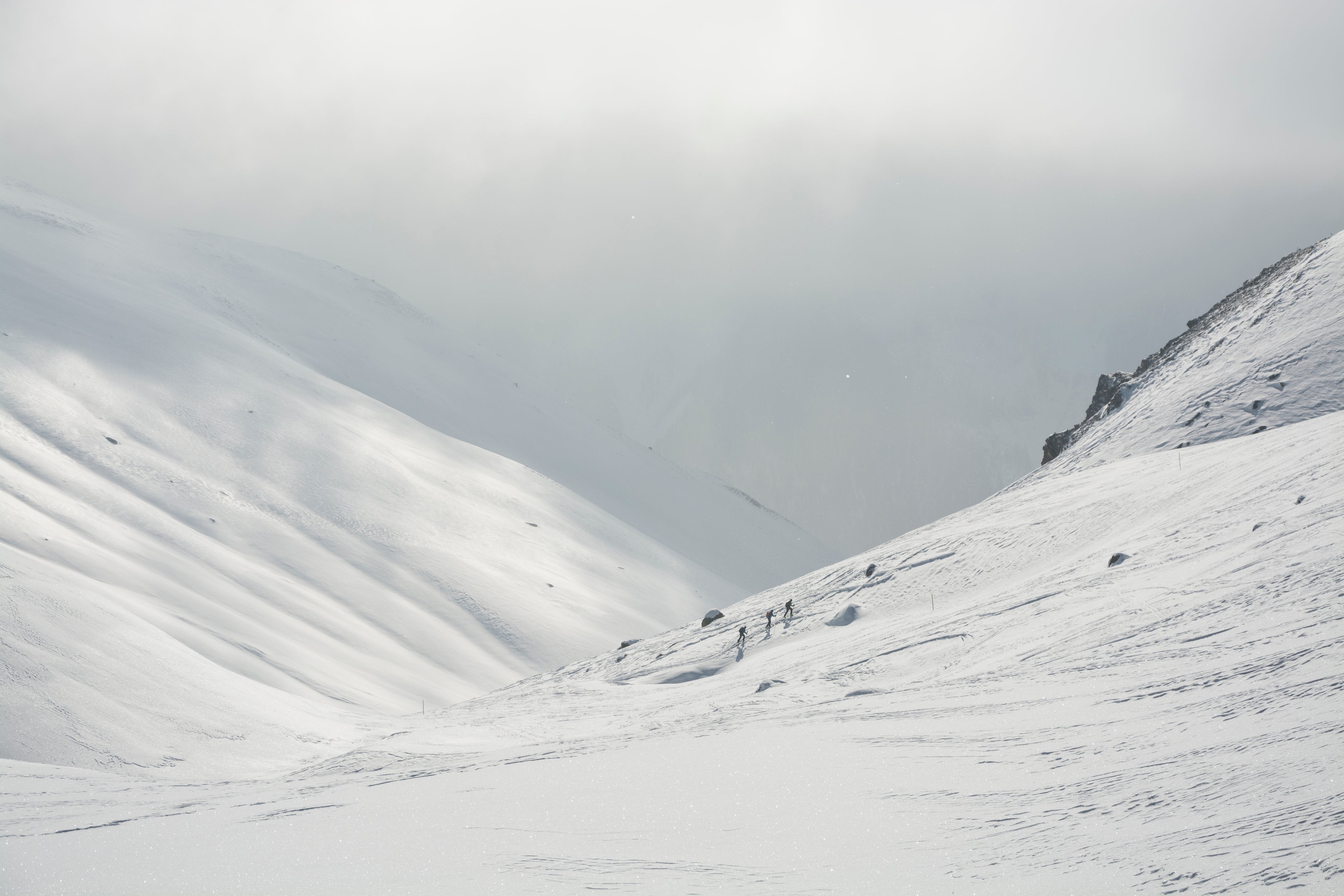 three-people-hiking-up-a-snow-covered-mountain.jpg